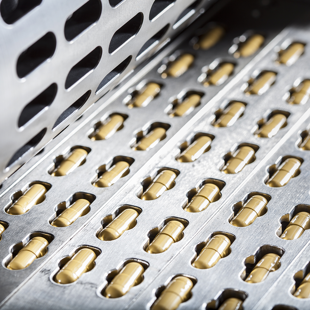 closeup of supplement capsules in manufacturing machinery