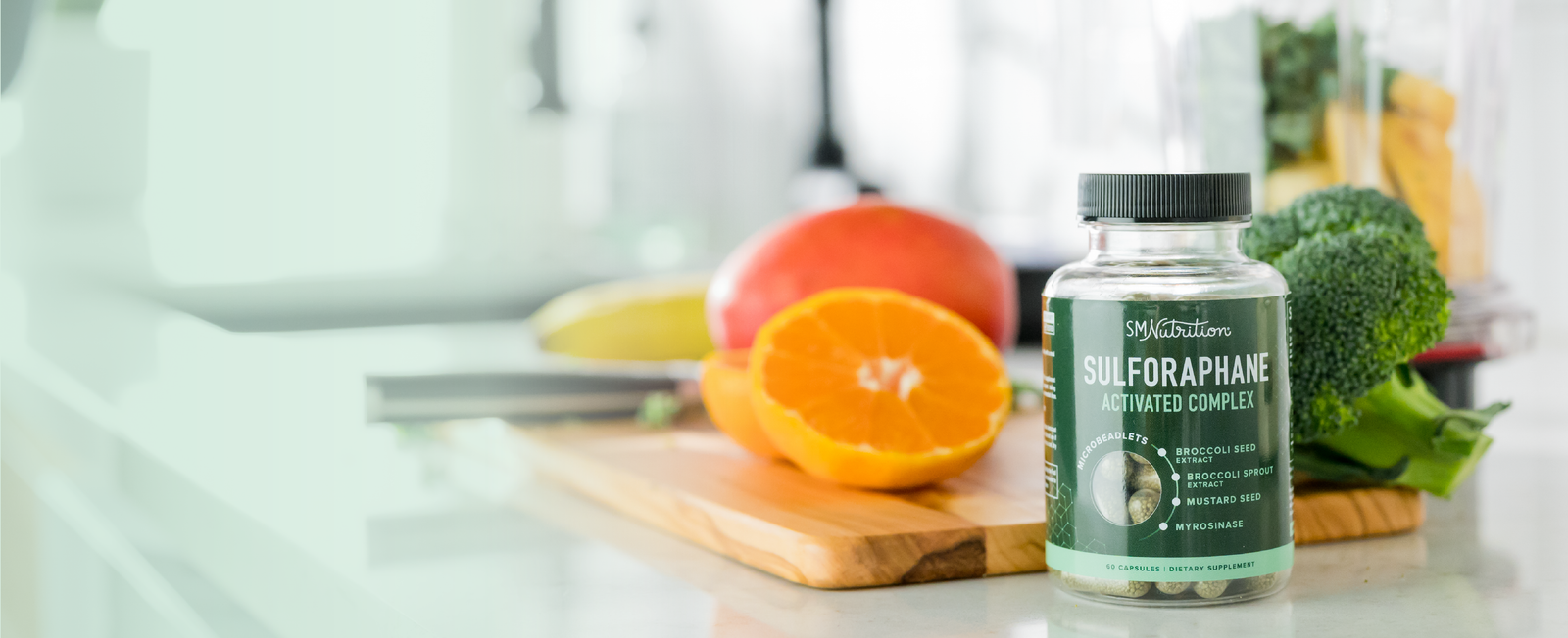 a bottle of Sulforaphane supplements by SM Nutrition sits on a kitchen counter in front of a wooden cutting board with fruits and vegetables